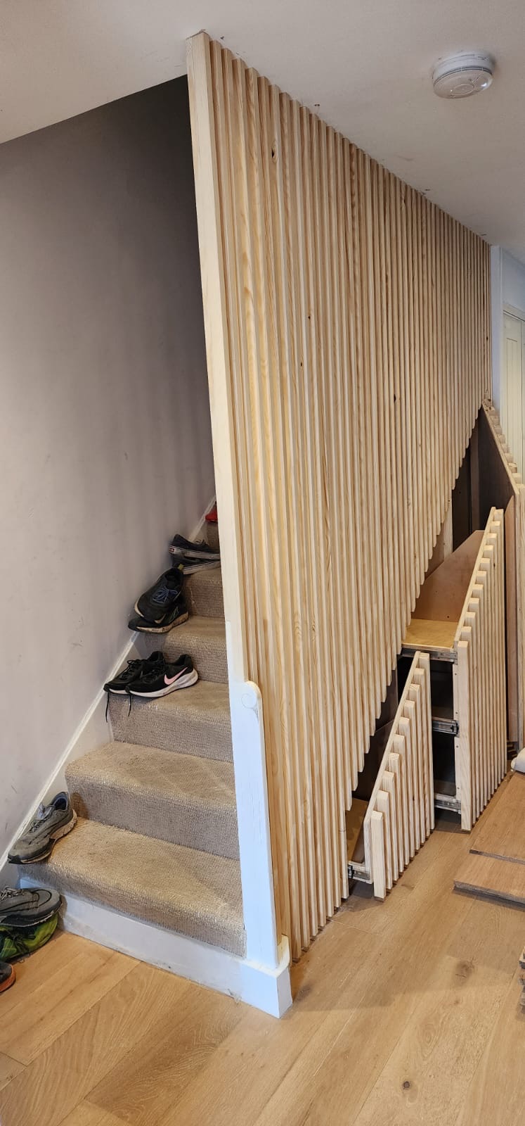 Custom designed and built wood cladded under stair storage unit